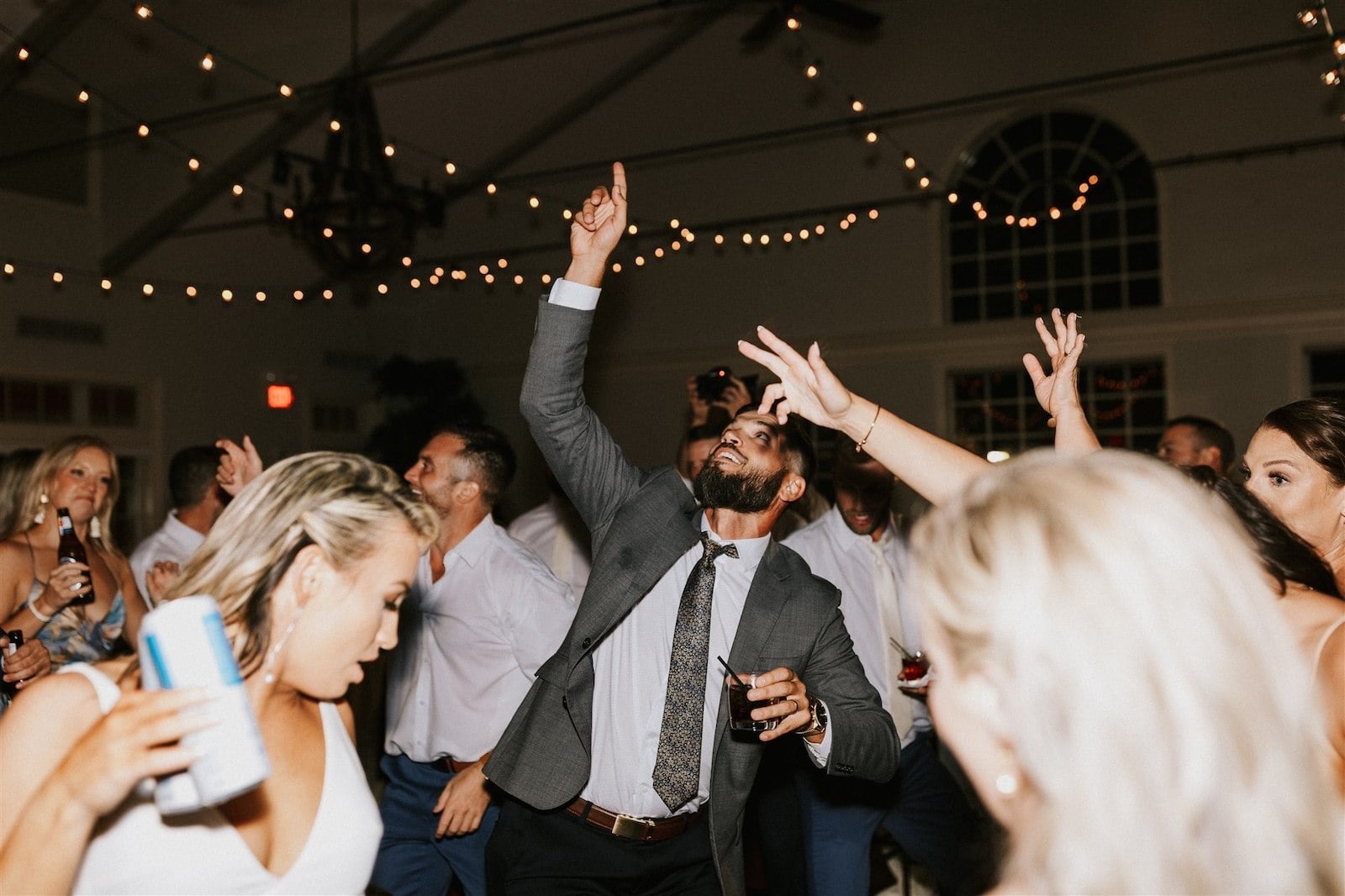 wedding guests dance with hands up