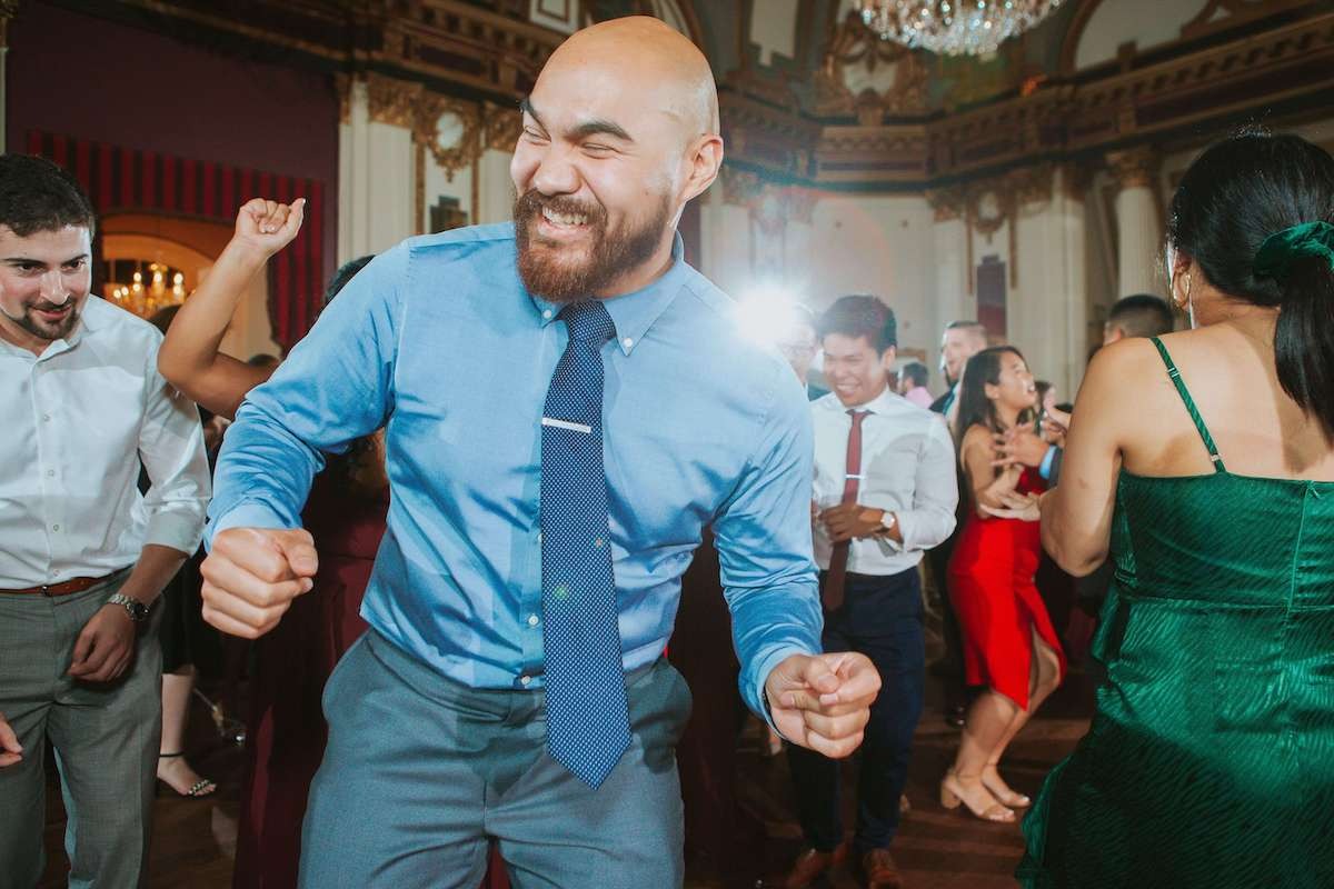 guy in blue shirt dancing at wedding