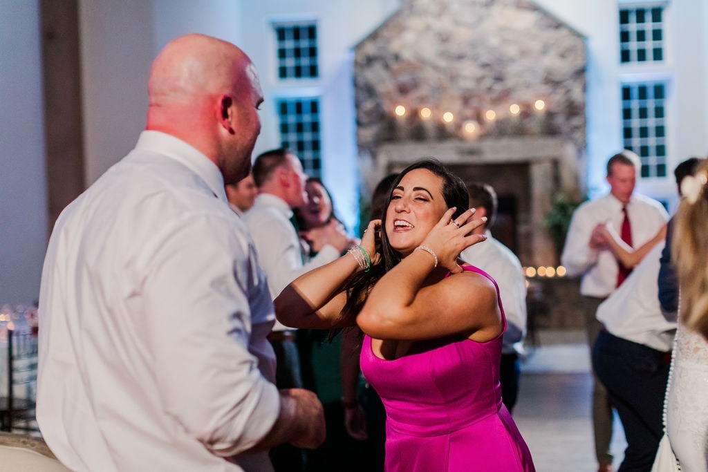 woman in pink dress dancing at wedding with man