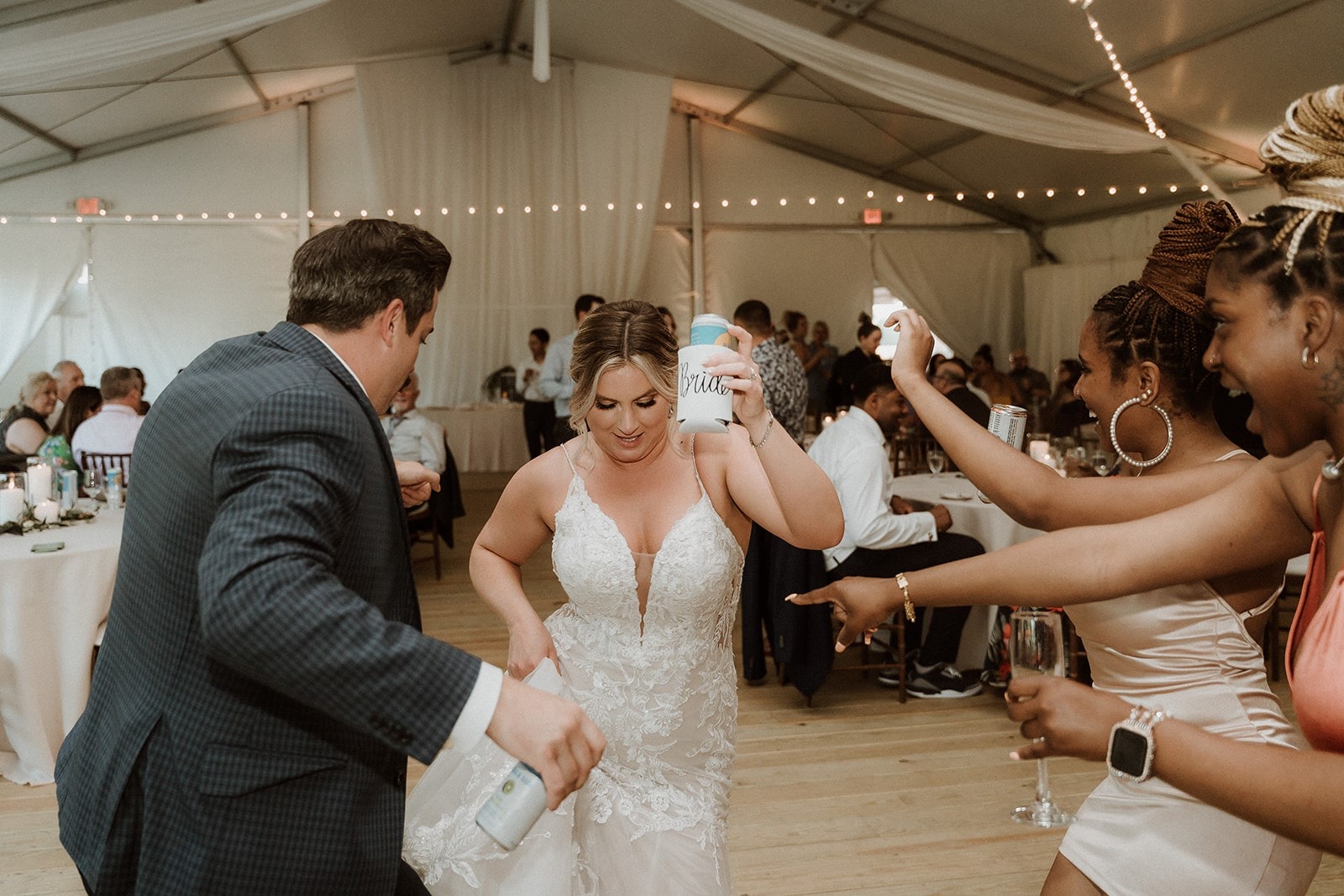 bride dancing with beer in hand and partying with friends