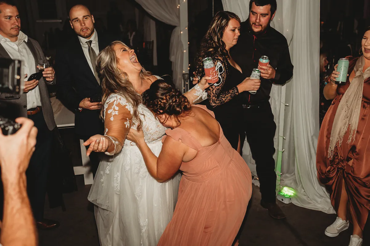bridesmaid putting her face in the bride's chest