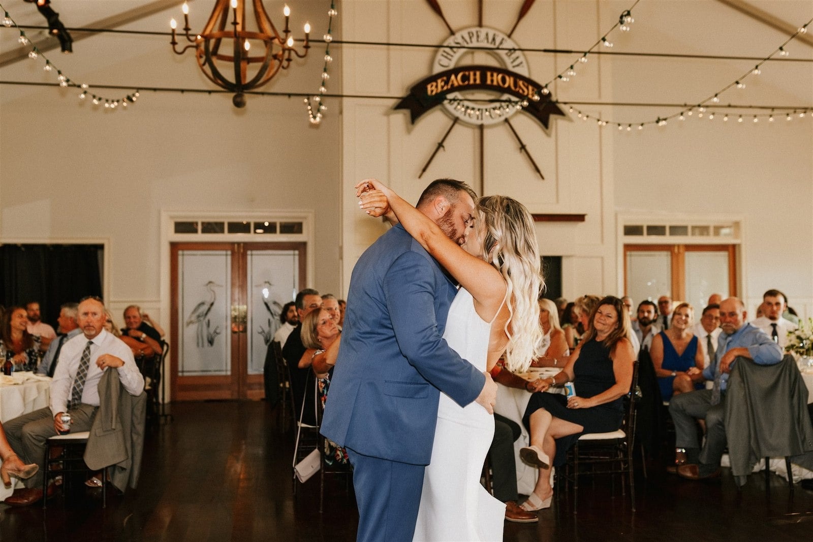 bride and groom kiss during first dance while guests watch from their seats