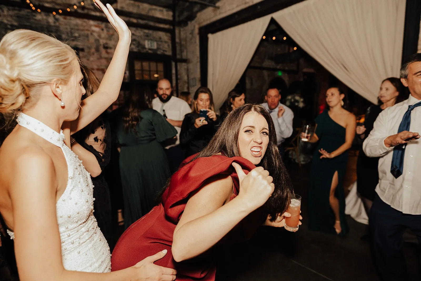 woman in red dress dancing in front of bride