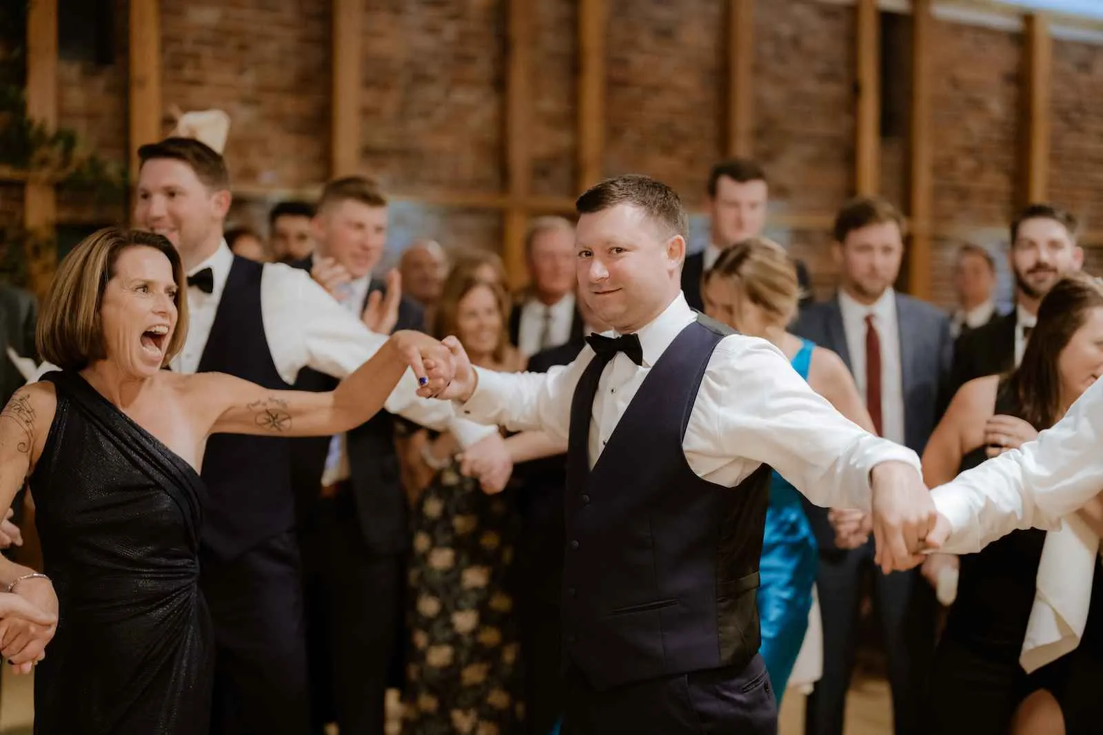 wedding guests holding hands while dancing in a circle