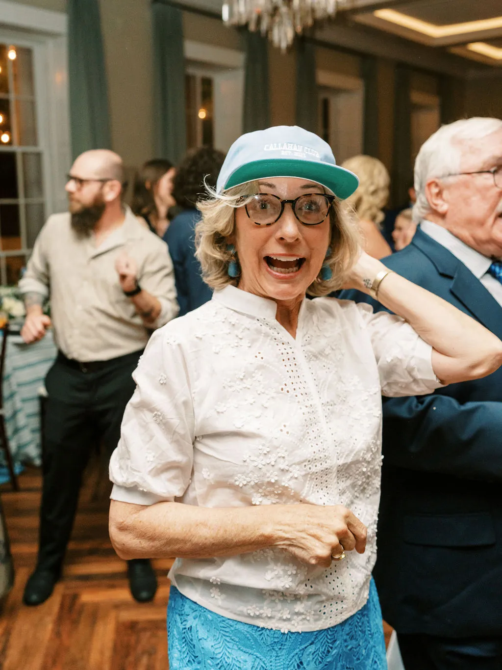 woman in baseball cap dancing at wedding