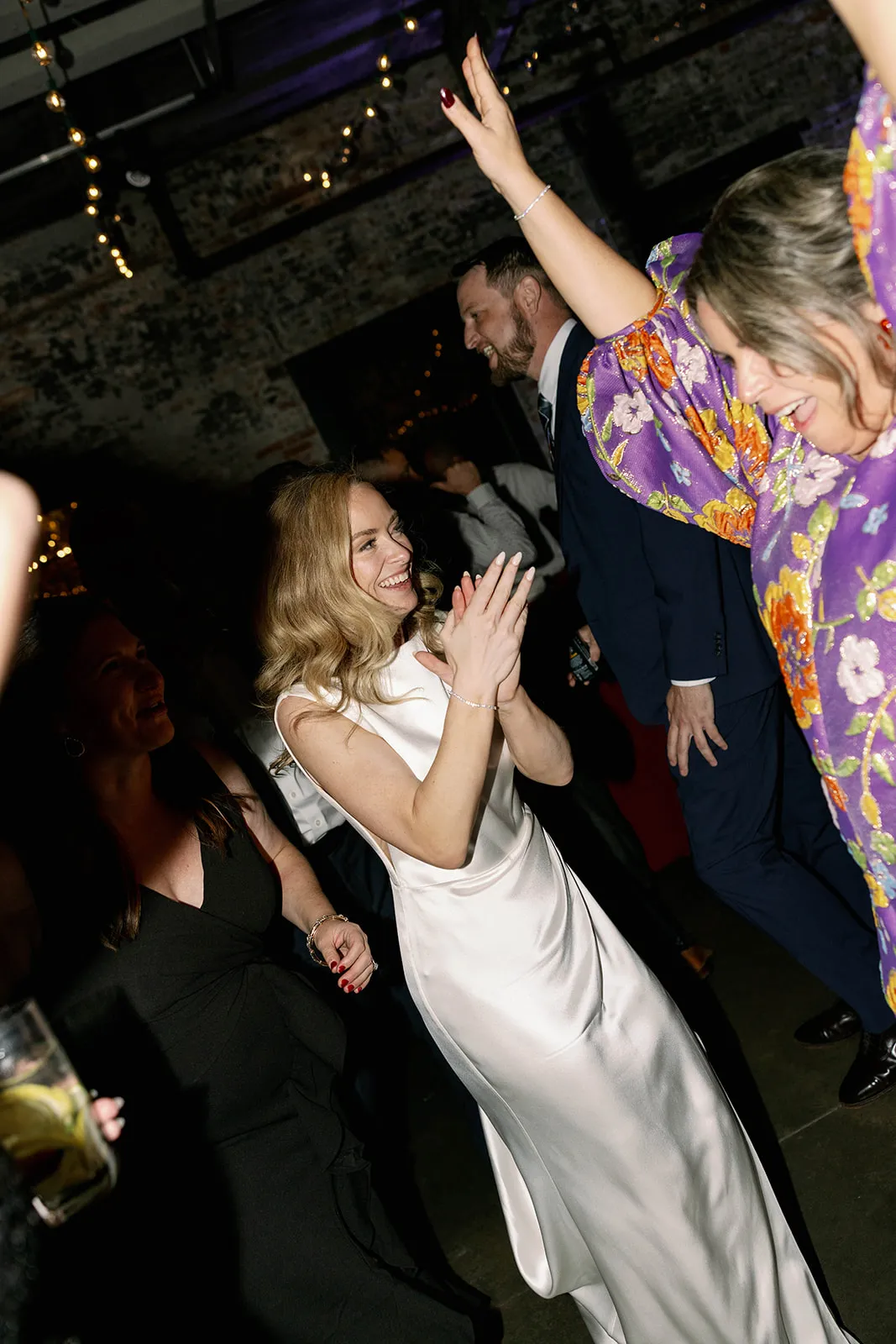 bride dancing with woman in floral dress