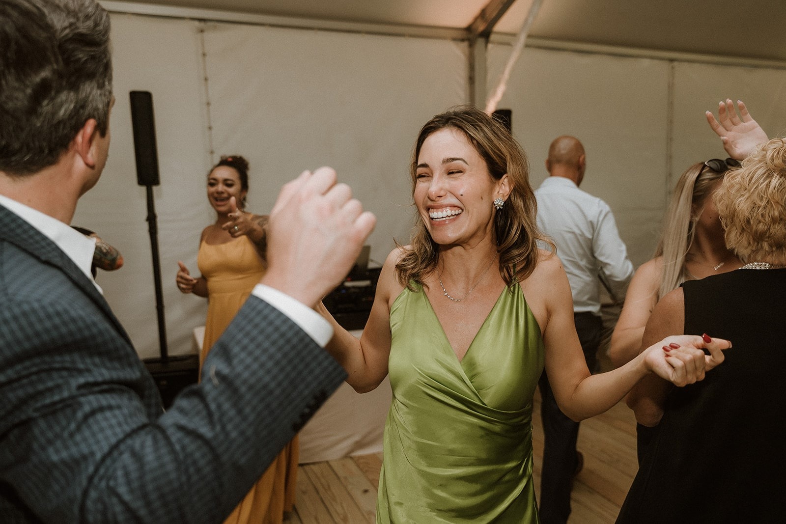 woman in green dress dancing at wedding