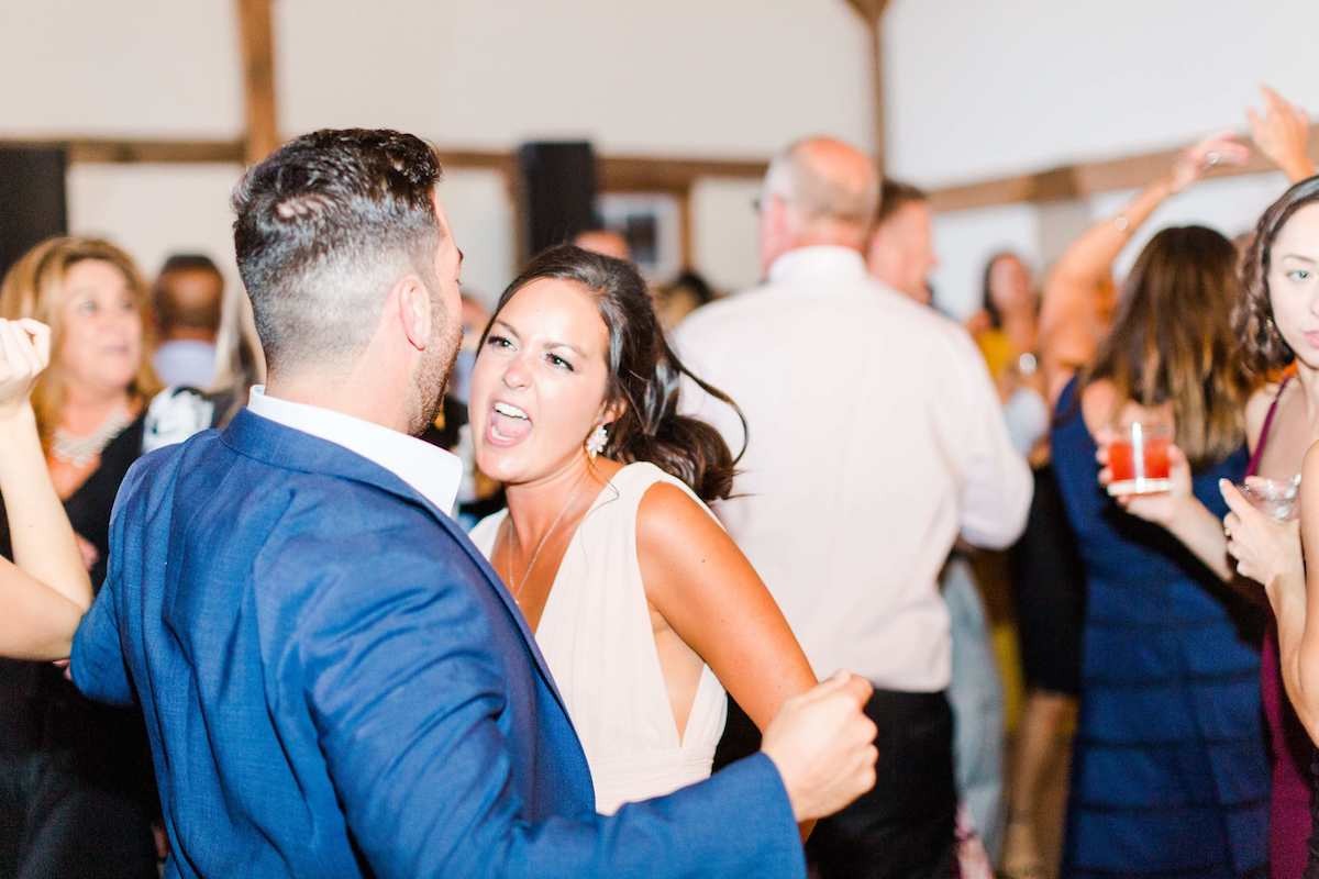 woman dancing with guy in blue suit at wedding