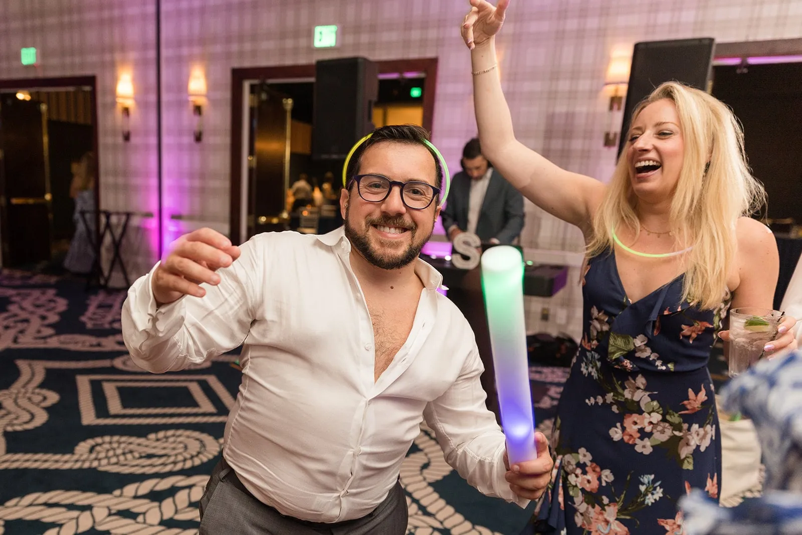 guy and woman dancing with light wands at wedding