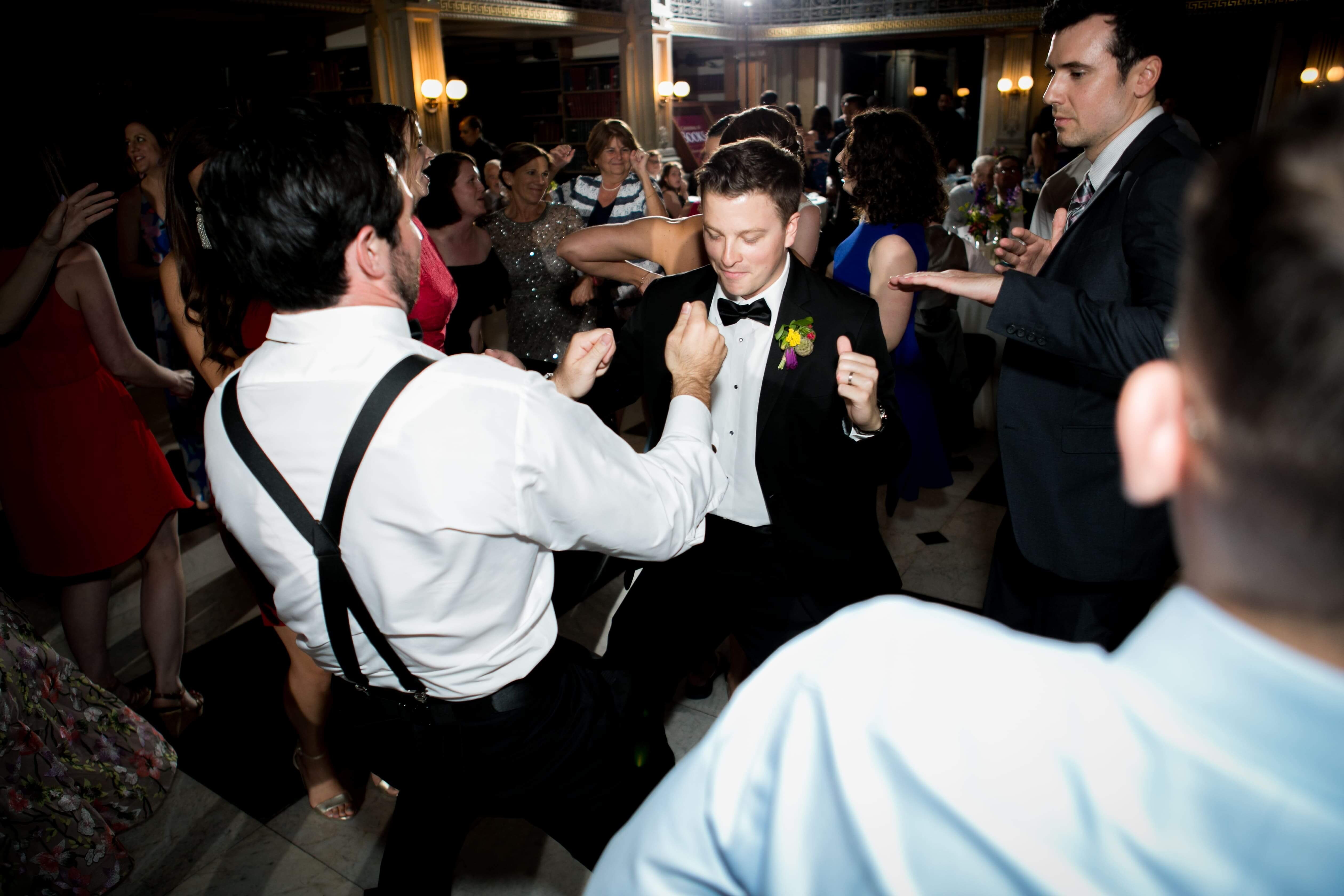 guys in tuxes dance at wedding