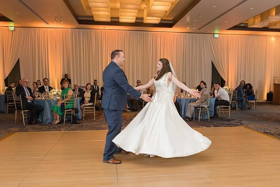 bride and groom first dance while guests watch