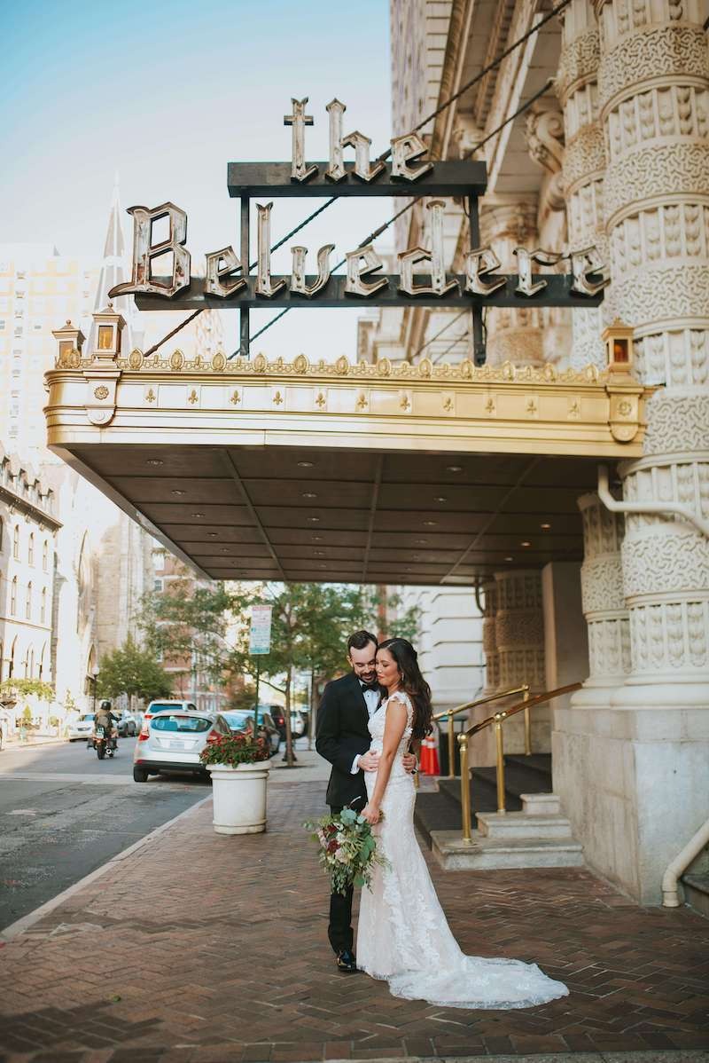 bride and groom pose outside of hotel