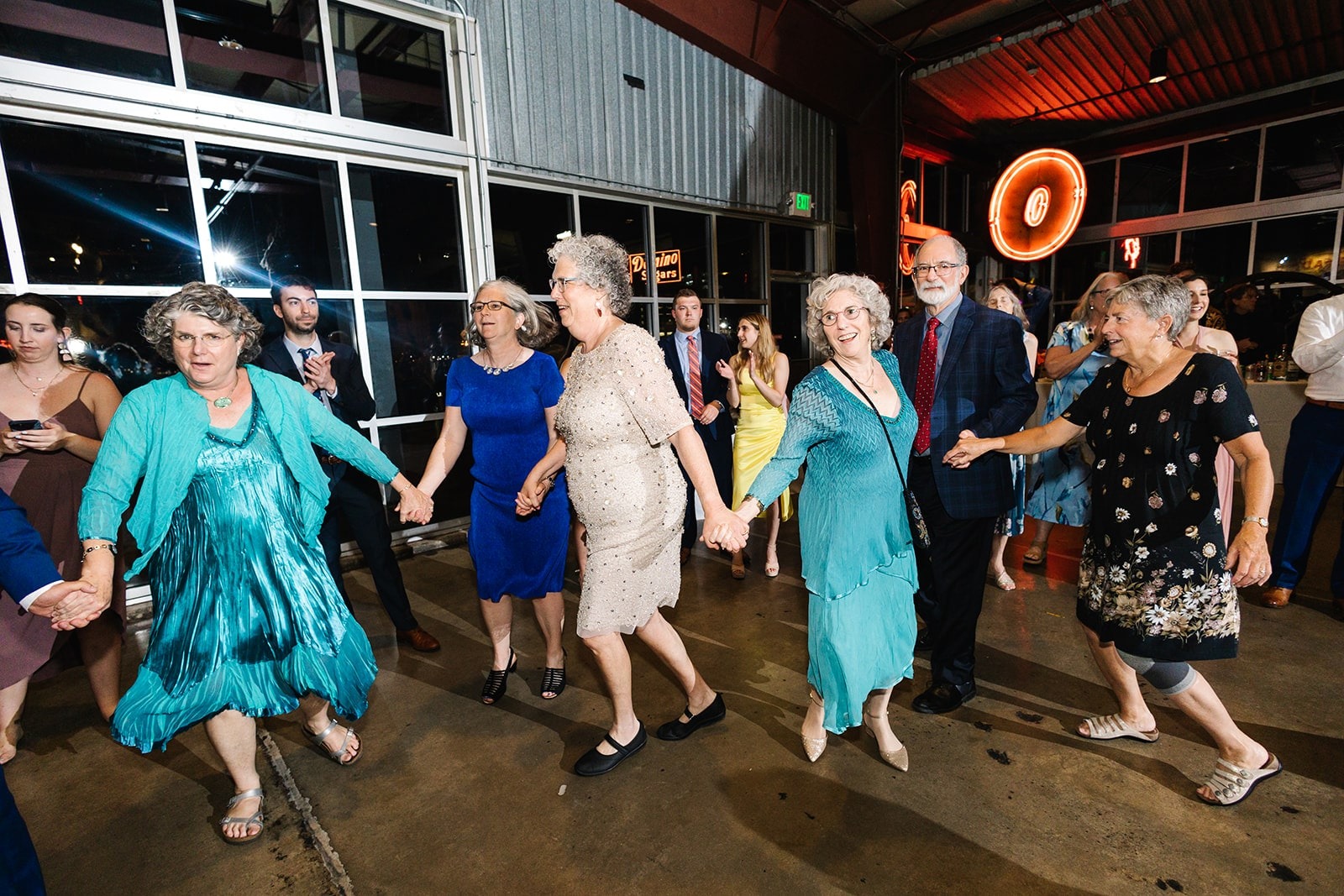 older women dance arm in arm around the hora center