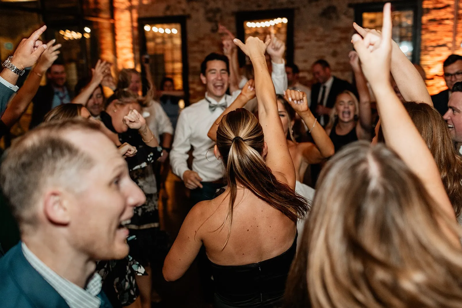 wedding guests dance with hands up