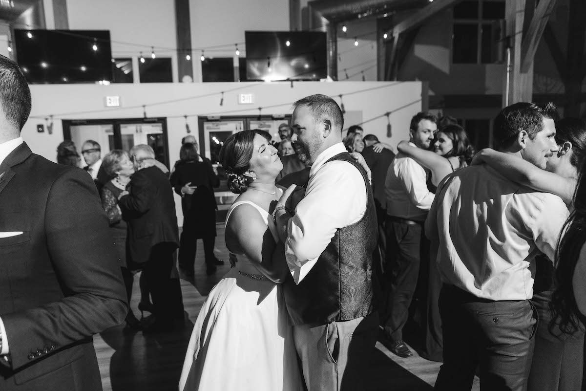 bride and groom slow dancing while other couples dance