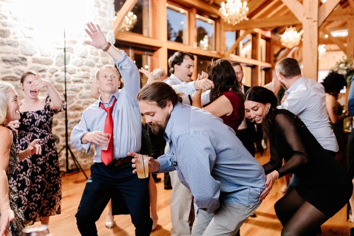 wedding guests squatting down and dancing 