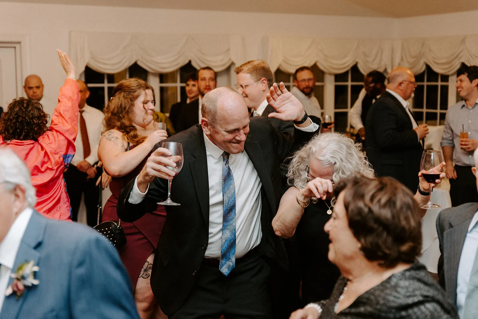 older man dancing with glass in hand
