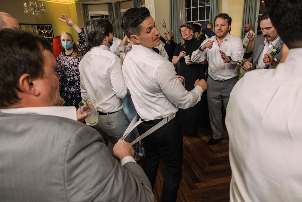guy holding on to groom's suspenders