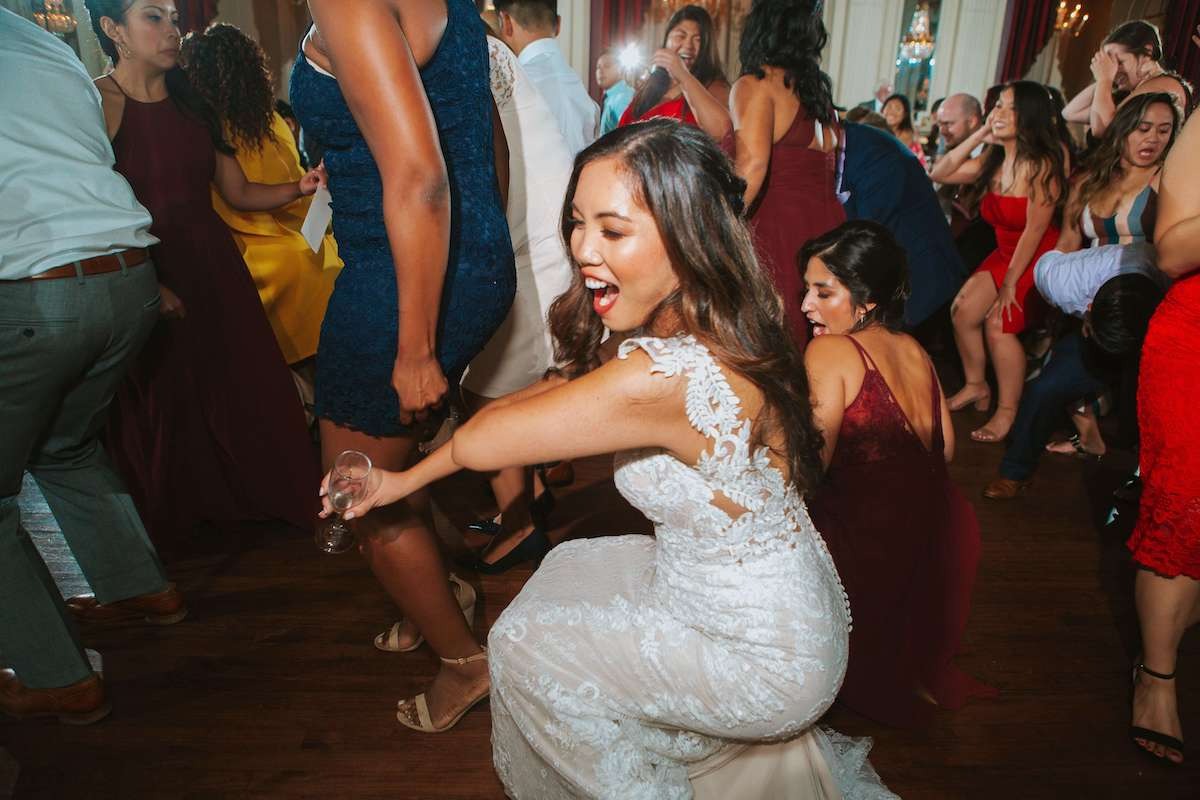 bride gets low at wedding surrounded by other women