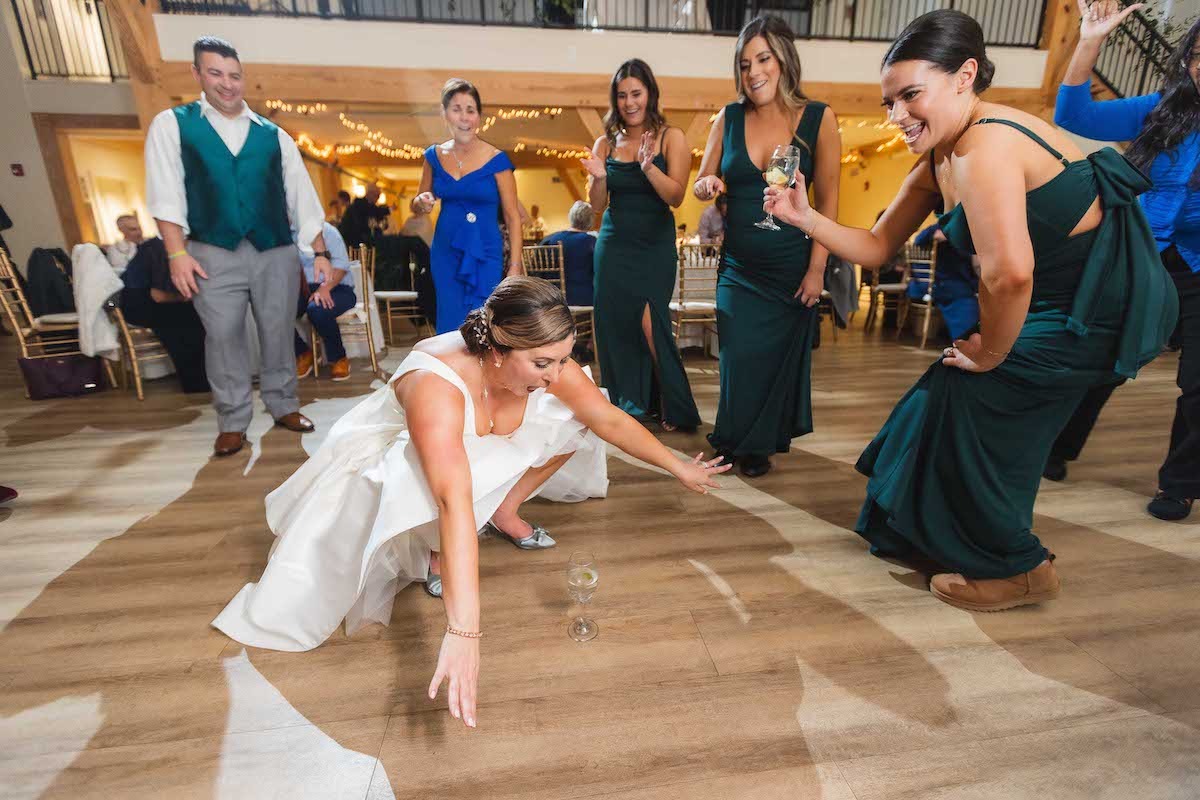 bride squatting low on floor dancing at wedding