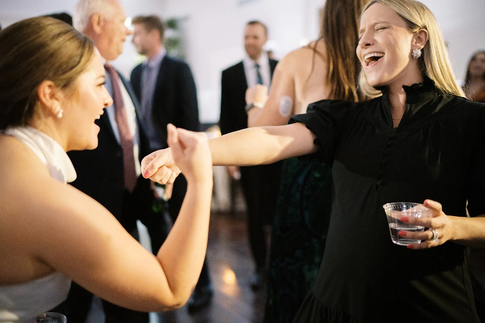 bride dancing with woman in black