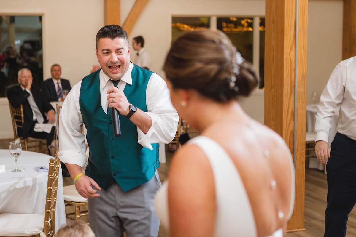 groomsman in green vest singing to bride