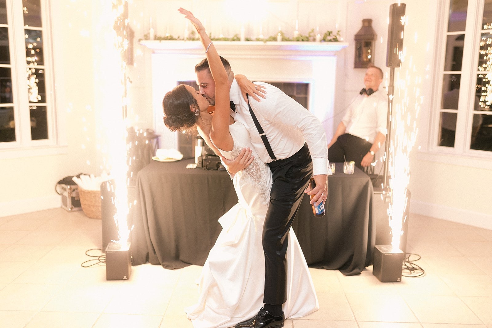 bride and groom kiss on dance floor with cold sparks going off