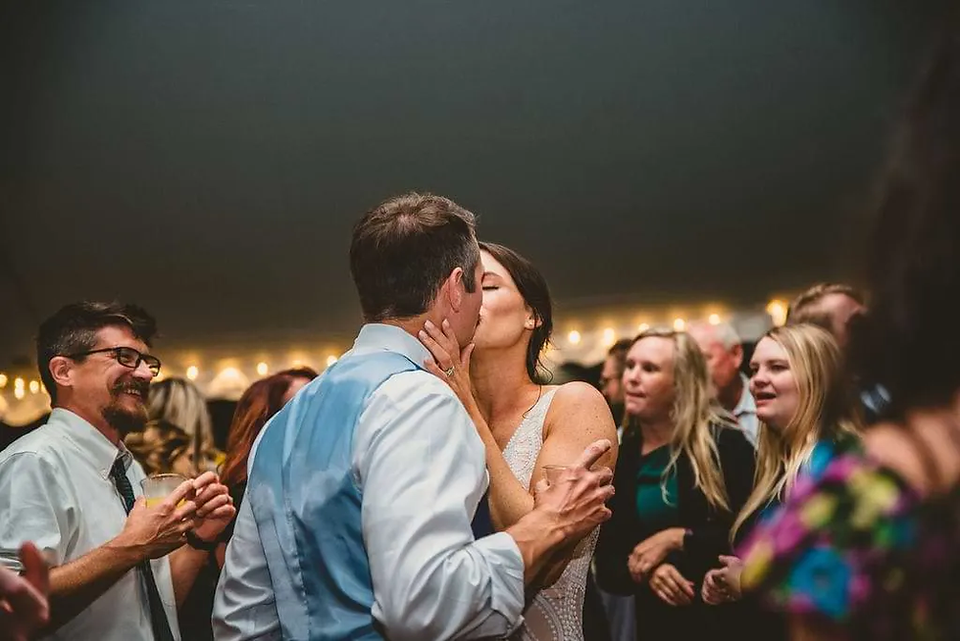 bride and groom kiss on the dancefloor of wedding