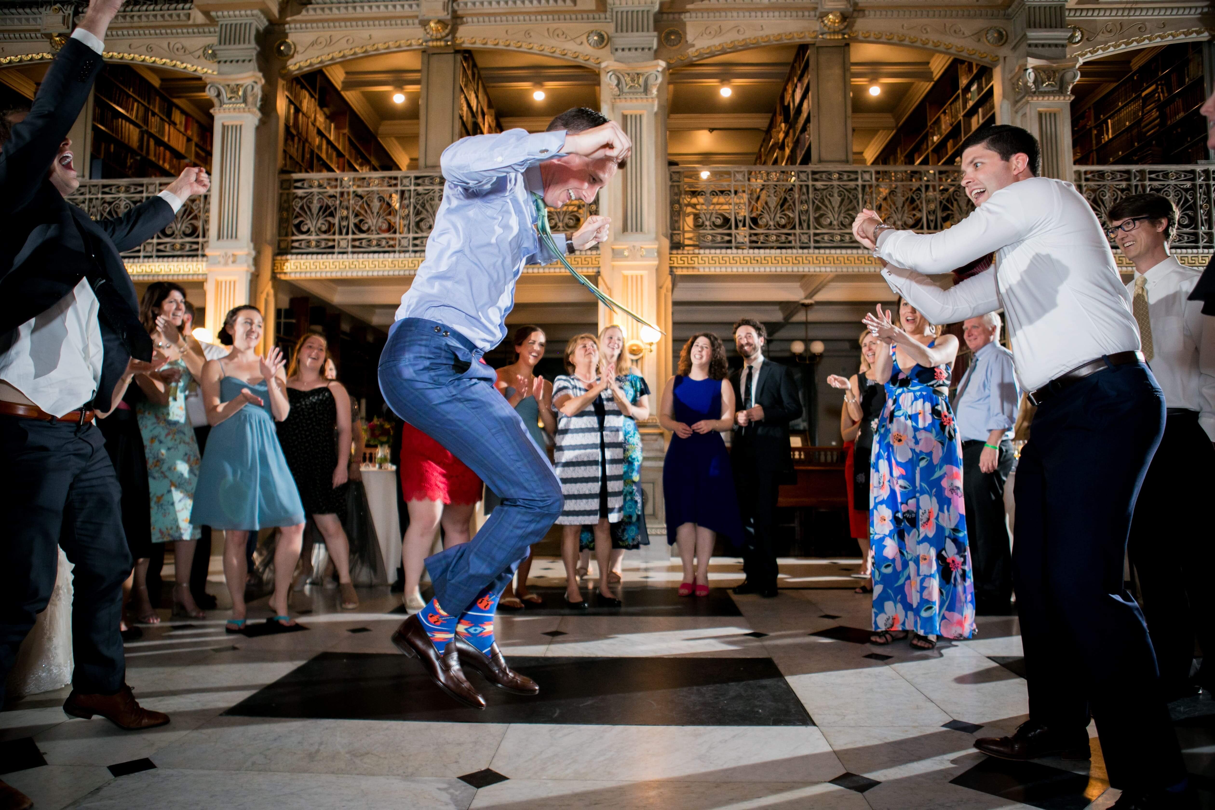 three men doing imaginary jump rope on dance floor at wedding