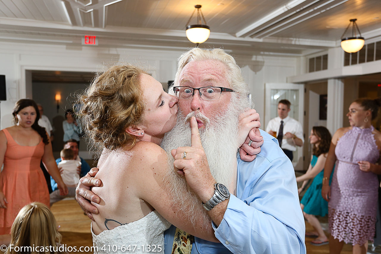 bride kissing guy with beard on the cheek