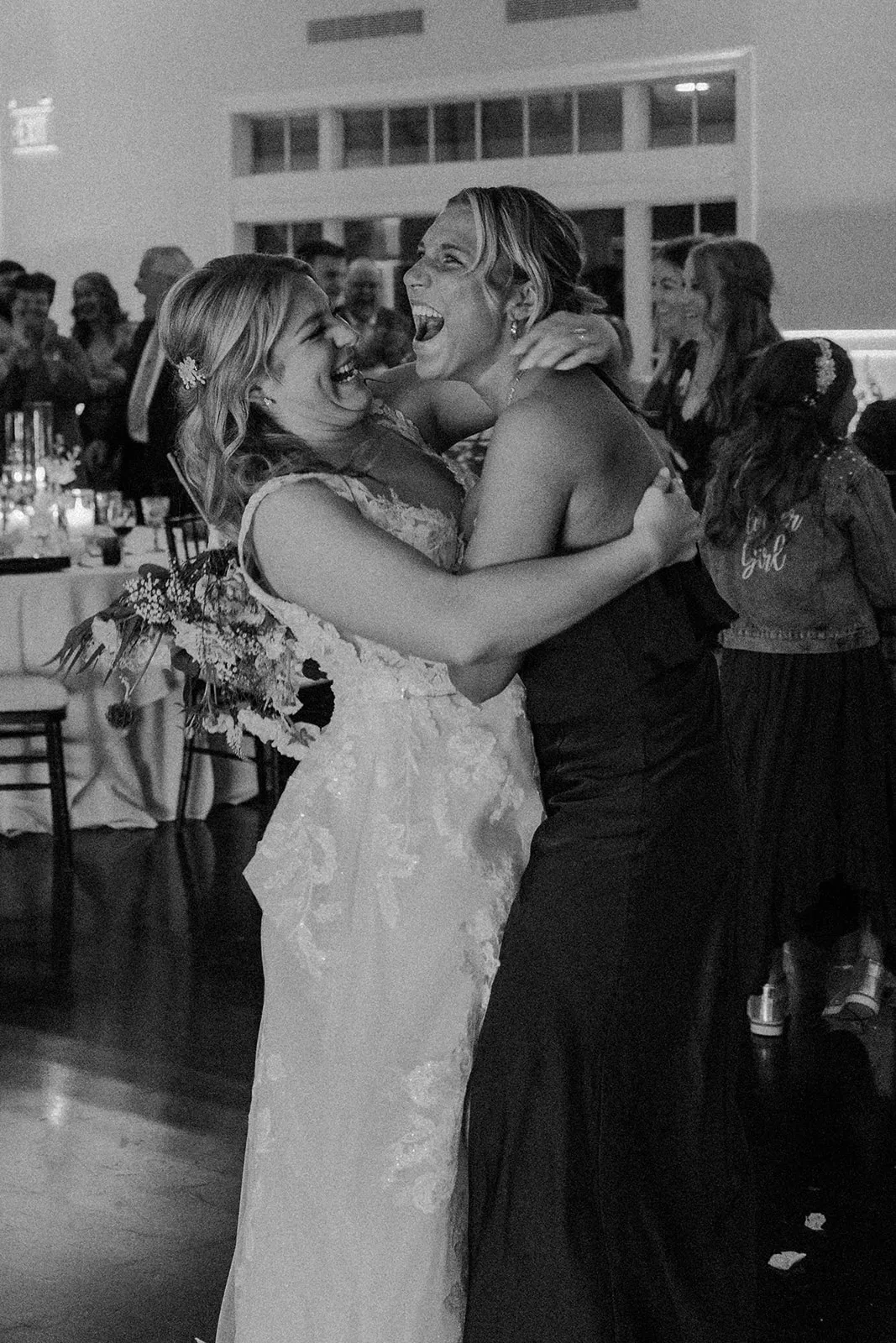 bride and woman dancing and hugging
