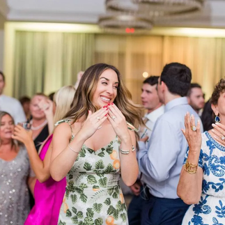 woman in green and white patterned dress dancing at wedding