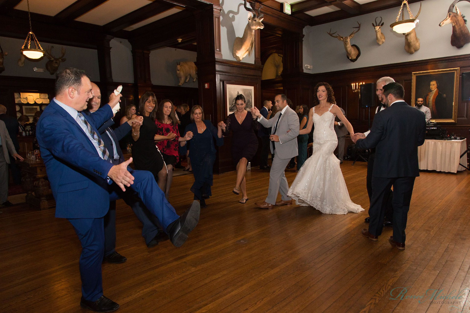 wedding guests kick legs out while dancing in semi circle