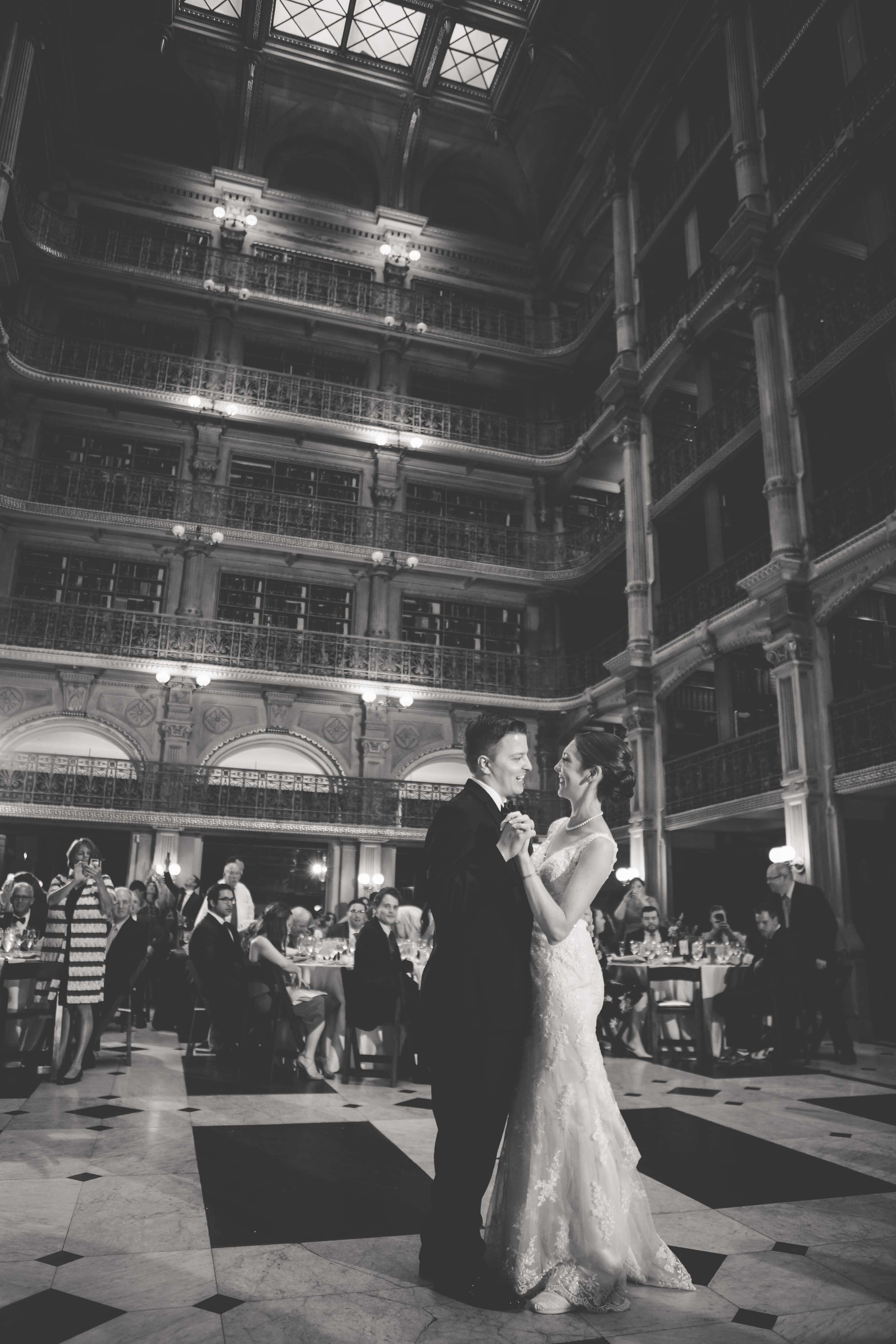 bride and groom first dance while guests watch at peabody library