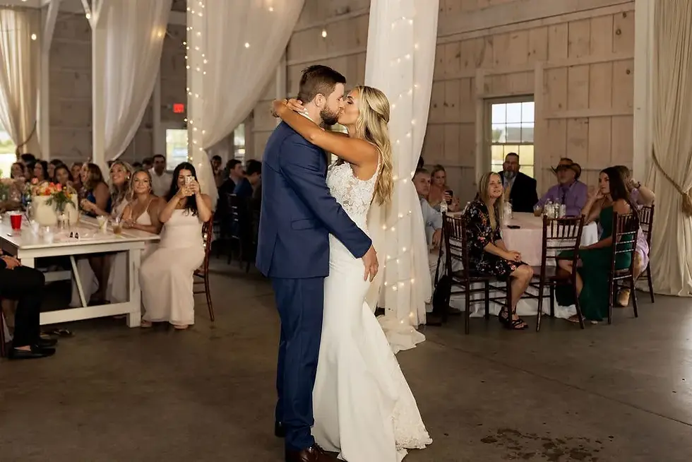 bride and groom kiss while doing first dance and guests watching