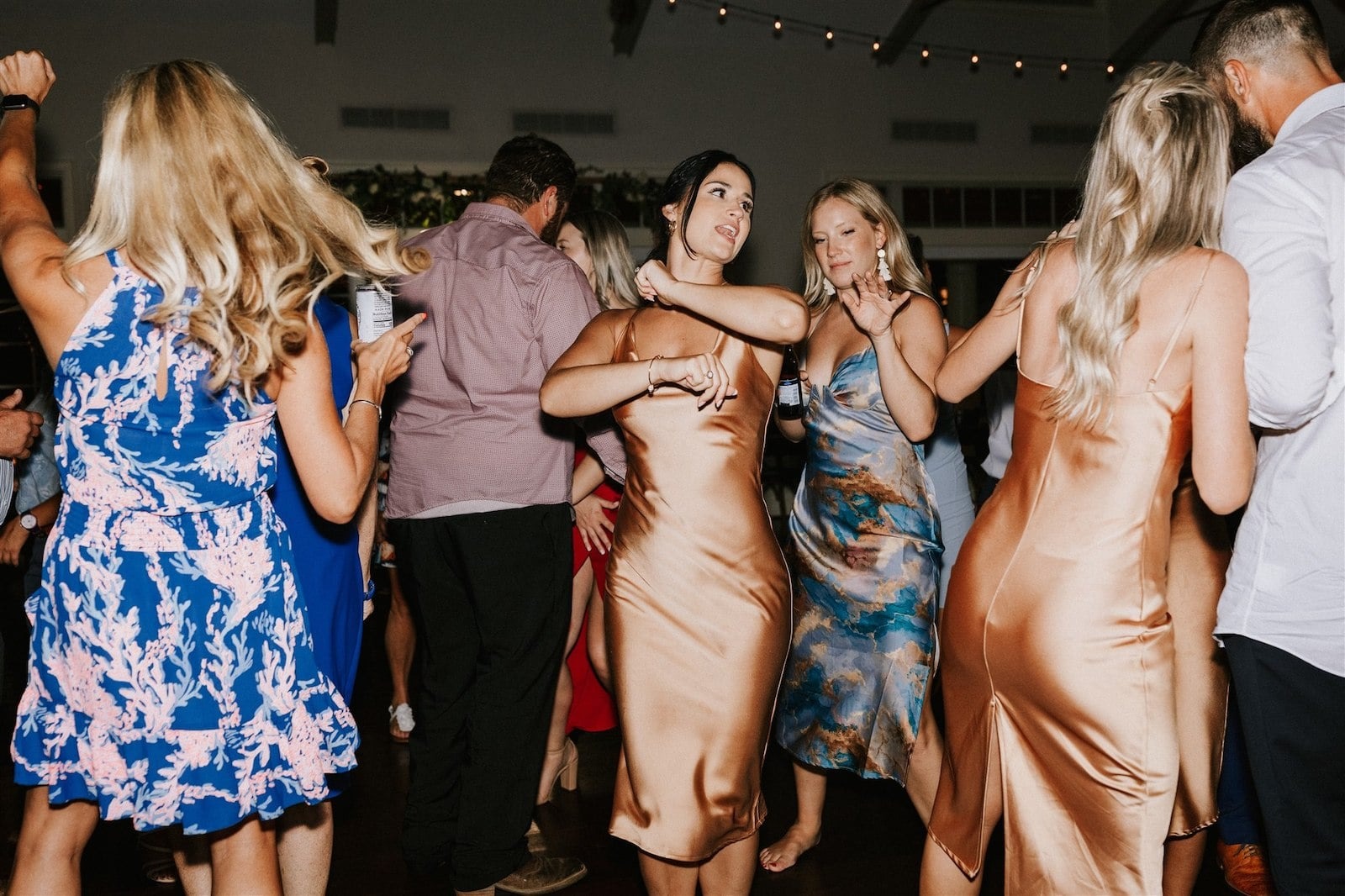 bridesmaid in copper-colored dress dancing at wedding