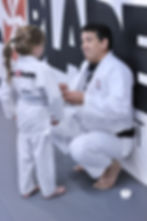 Young Six Blades Jiu-Jitsu student receiving stripe on her grey white belt