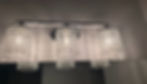 Three-light crystal vanity fixture above a bathroom mirror