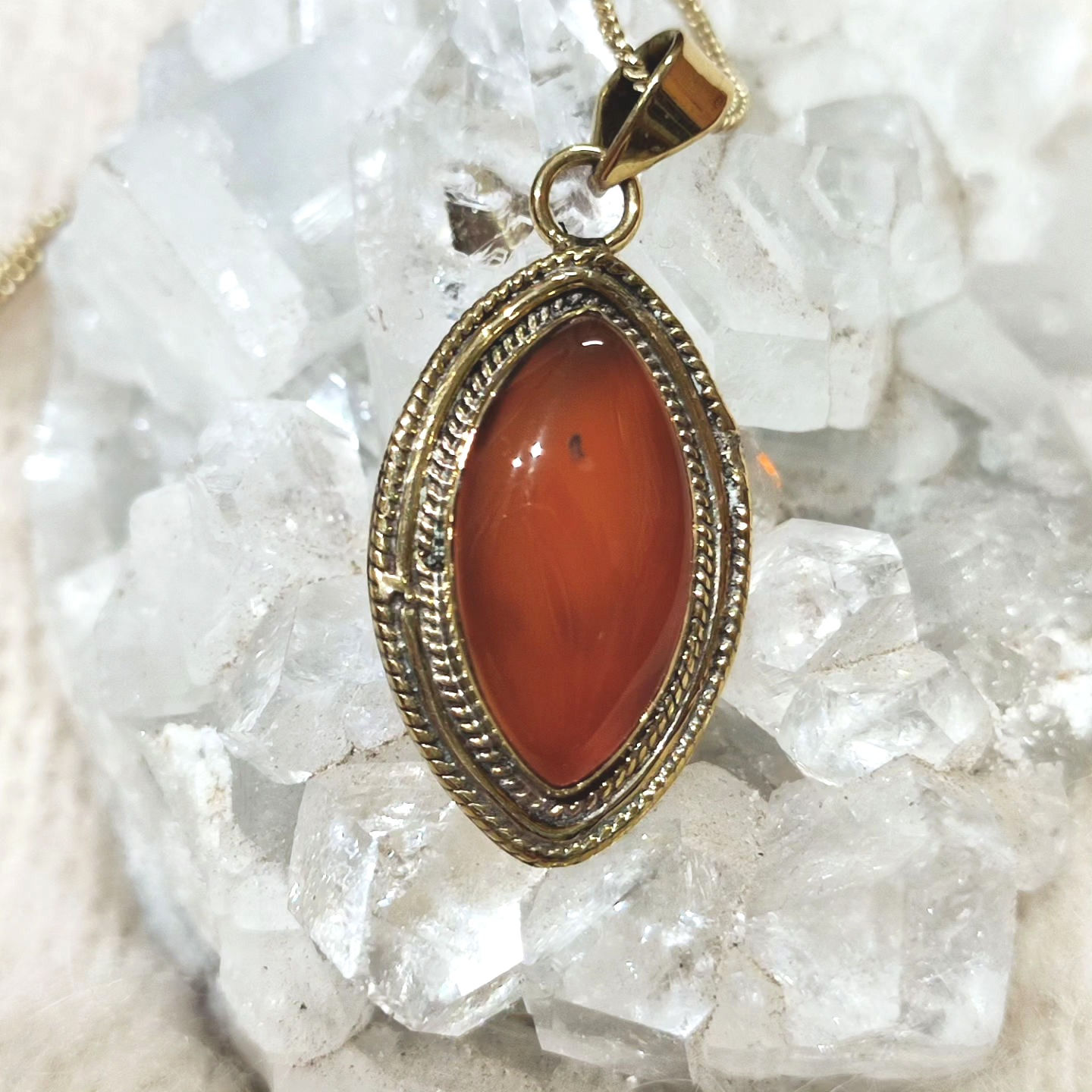 Brass pendant with orange calcite stone