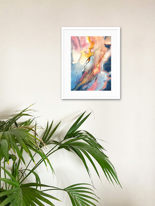 Original abstract watercolour painting Pulse displayed in a white frame on a light wall above a green palm plant.