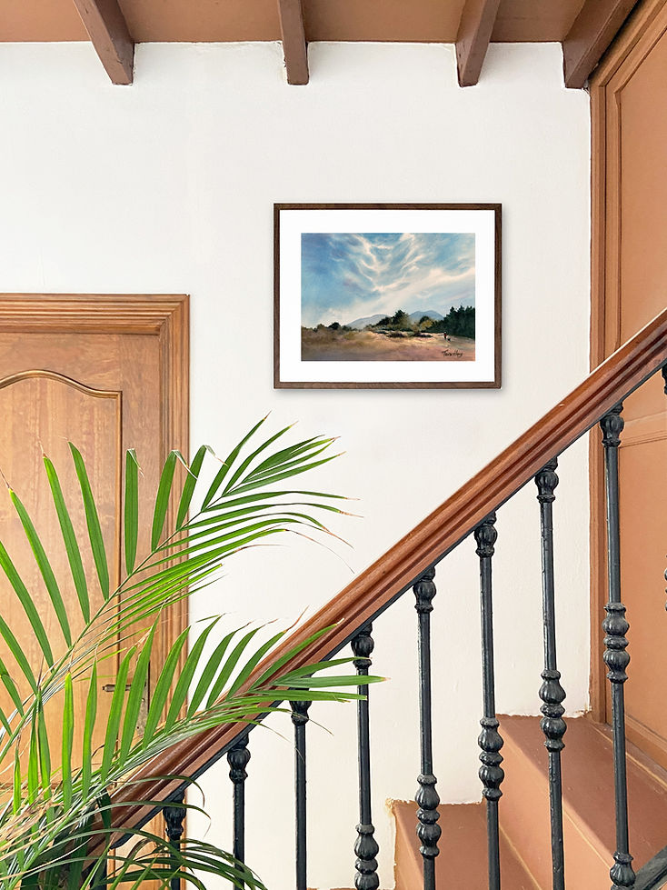 Original watercolour painting Belonging displayed in a dark wooden frame on a white wall above a staircase in a traditional home interior.