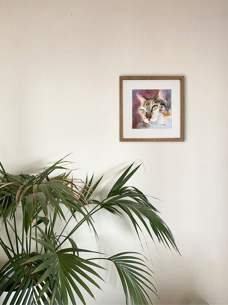 Original watercolour painting Happiness displayed on a white wall above a palm plant in a home interior.