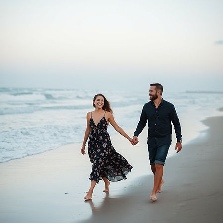 happy couple walking on the beach from left to right in the distance.jpg