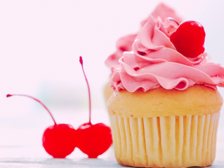 cupcake with pink frosting and cherries