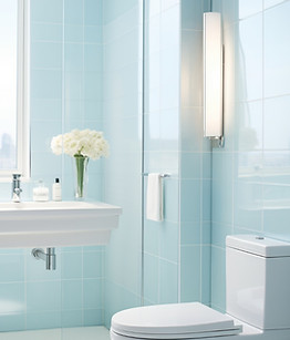 baño moderno con azulejos de color azul claro en las paredes. A la derecha, se encuentra un inodoro blanco, y justo frente a