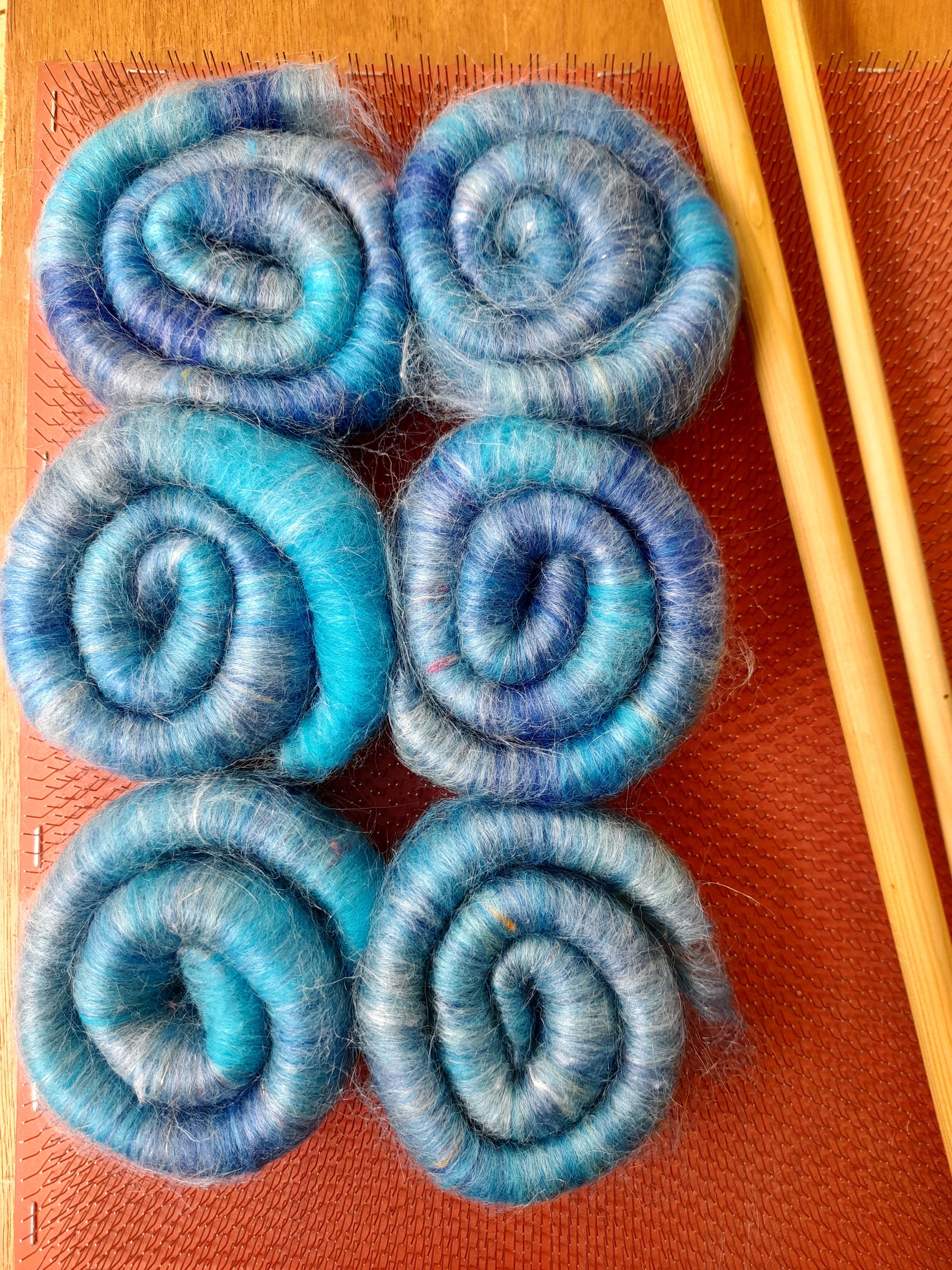 Blended fibre rolags on a blending board with dowels