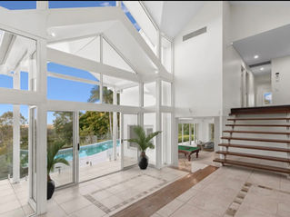 Light-filled architectural atrium with view over outdoor swimming pool