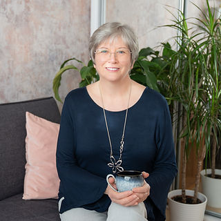 Suzanne Smith sitting iwth a cup of tea, smiling at the reader