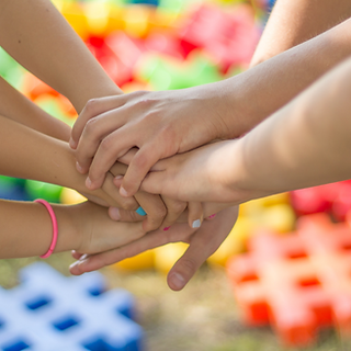 Group of clasped hands showing that it's all about reconnection