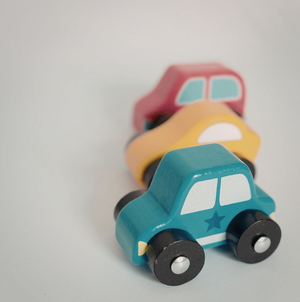 three wooden toy cars, one red, one green, one ywllow